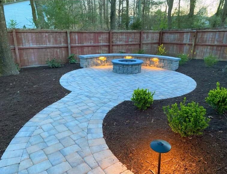 Real fire pit paver patio with landscape lighting, built by Lanier Landscape & Hardscape