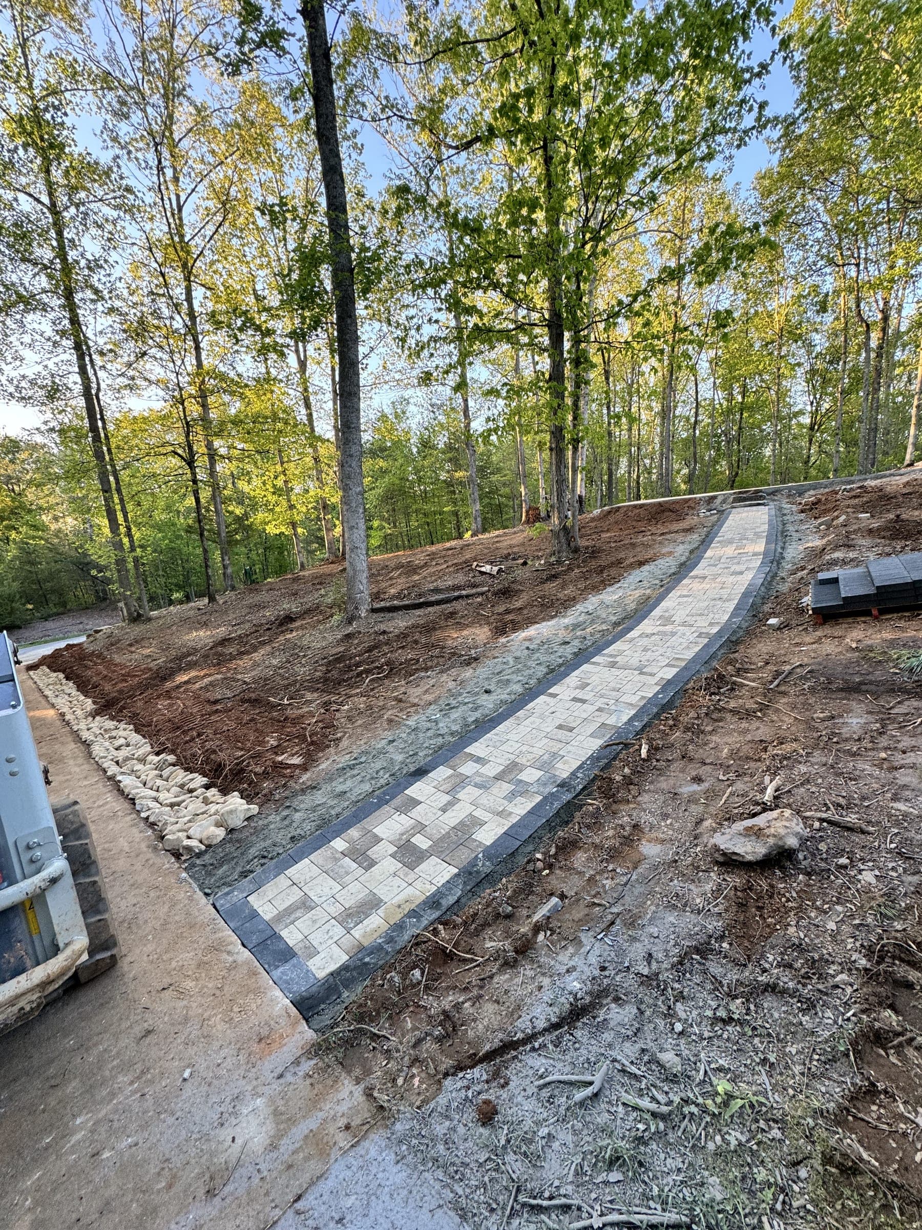 Stone-lined drainage channel running along a yard