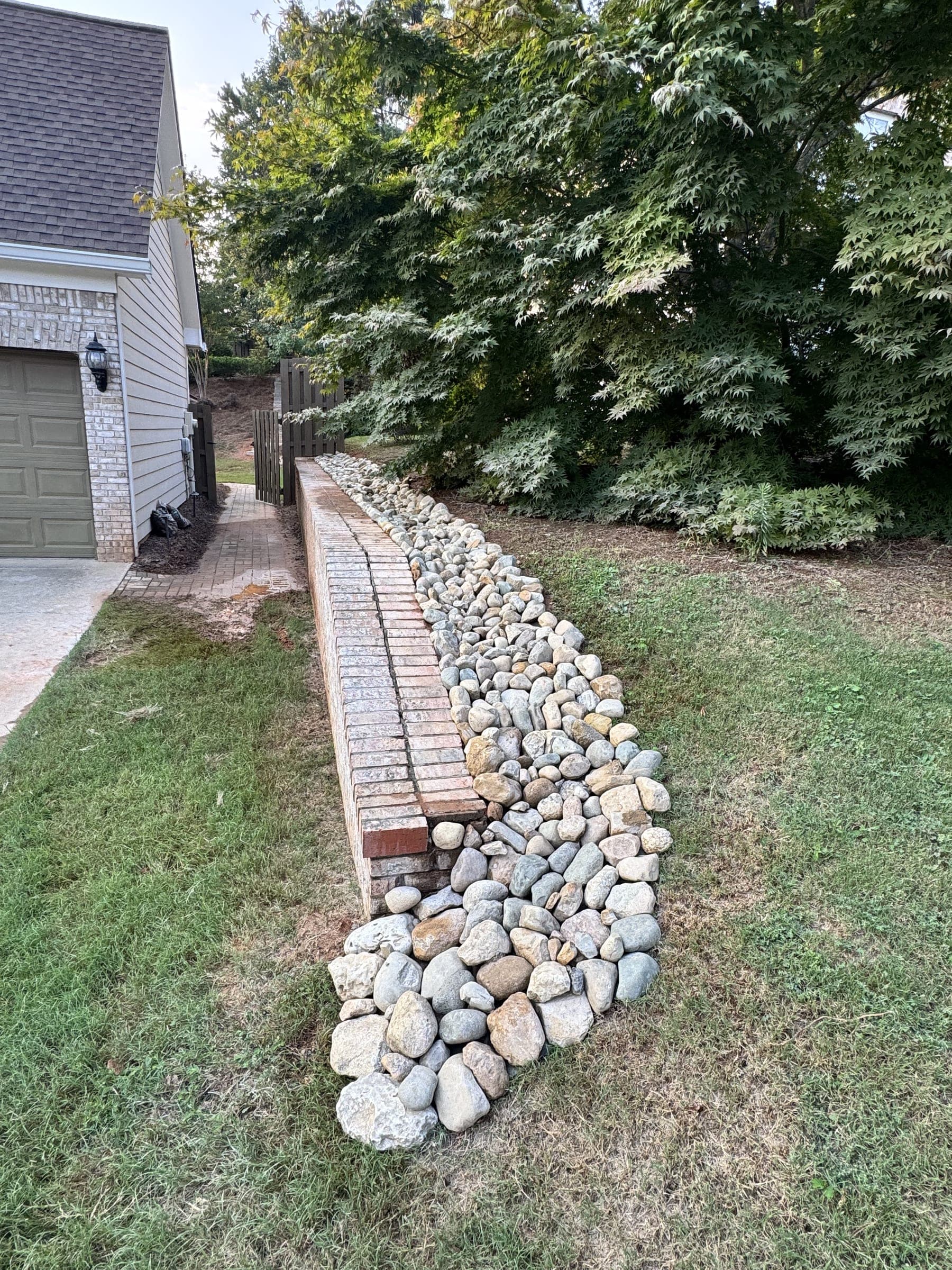 Stacked stone edge along a lawn with drainage rock