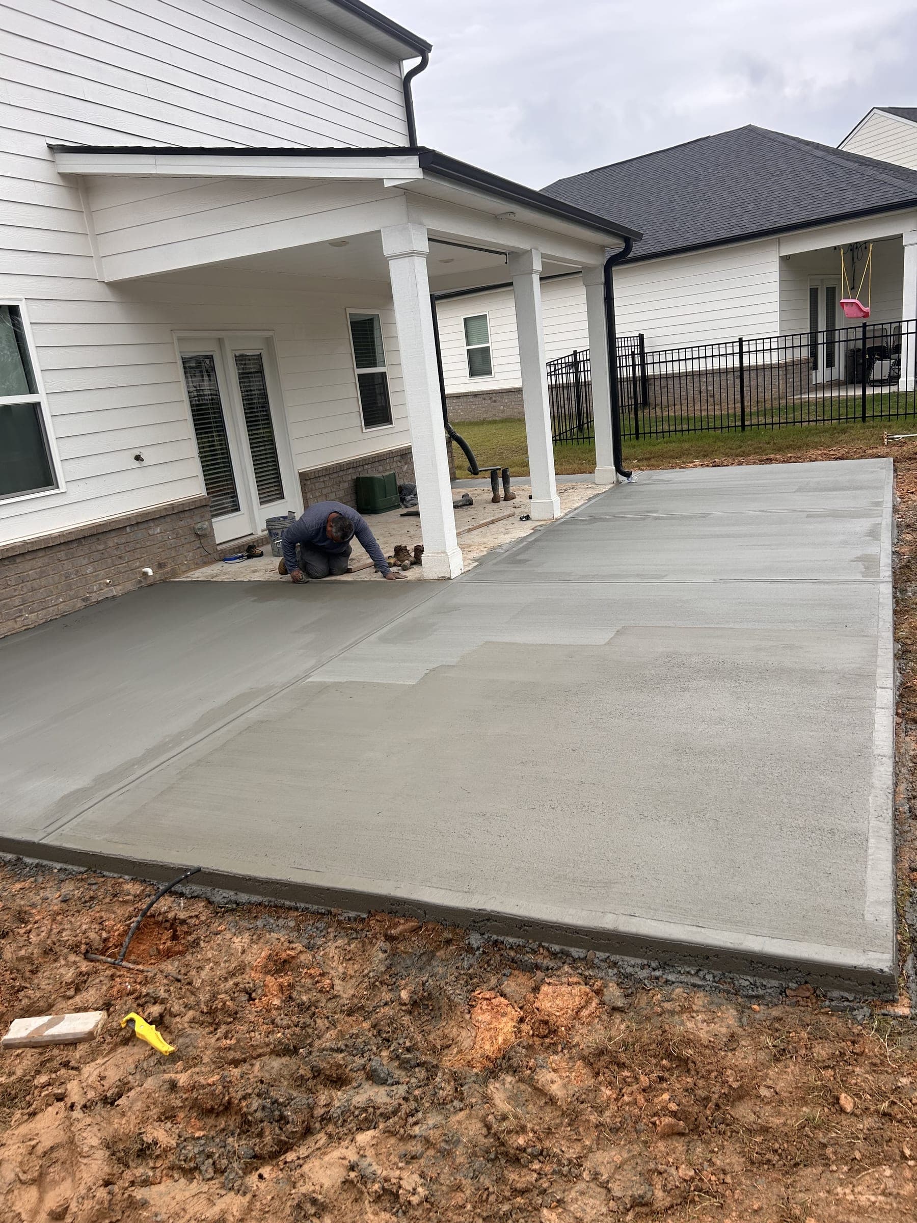 New concrete patio under a covered back porch