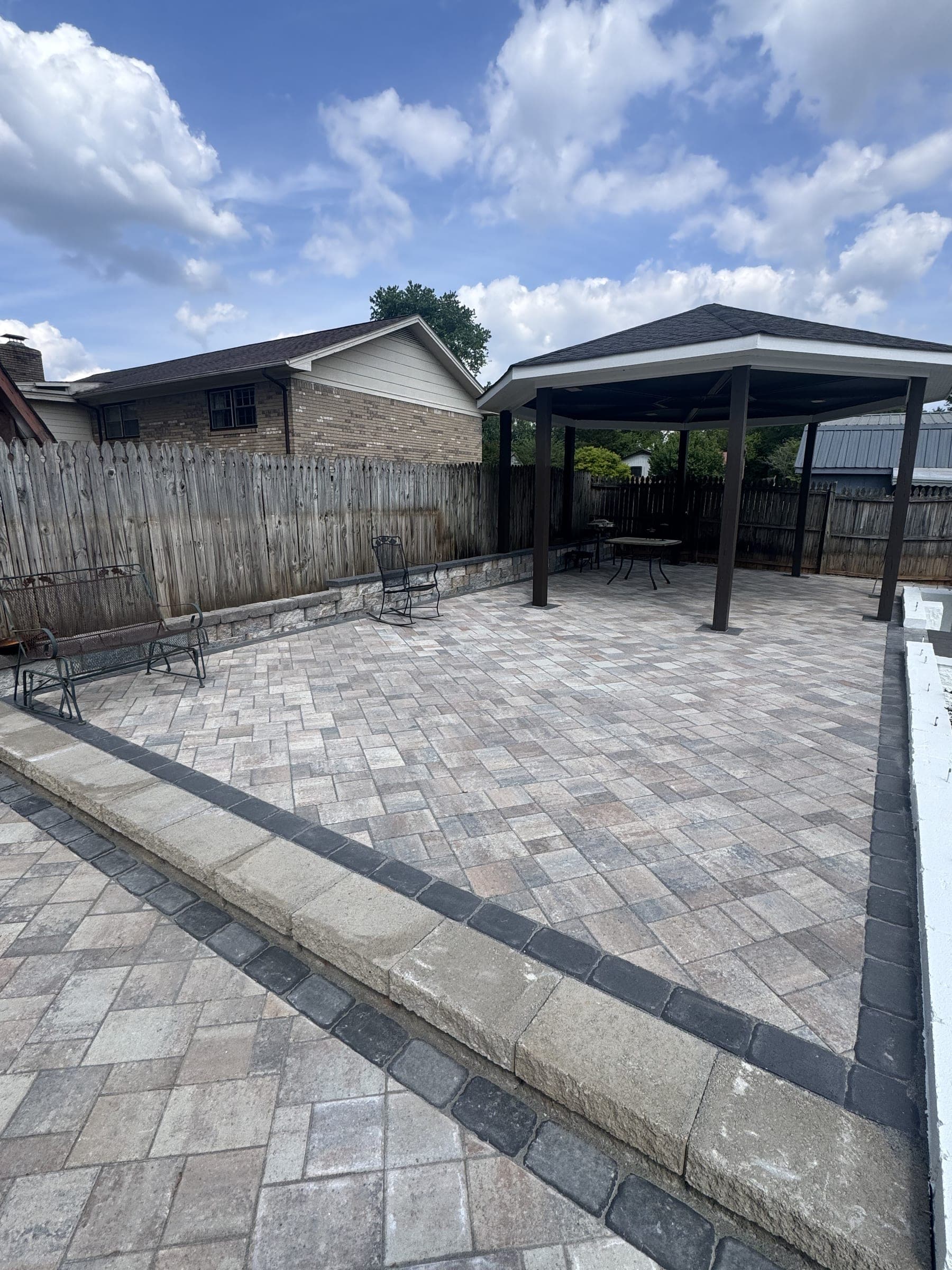 Paver patio next to a covered pergola