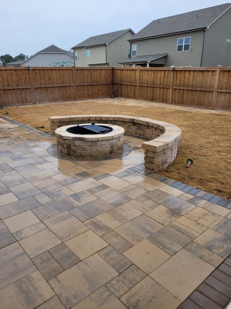 Paver patio with a stone fire pit surround