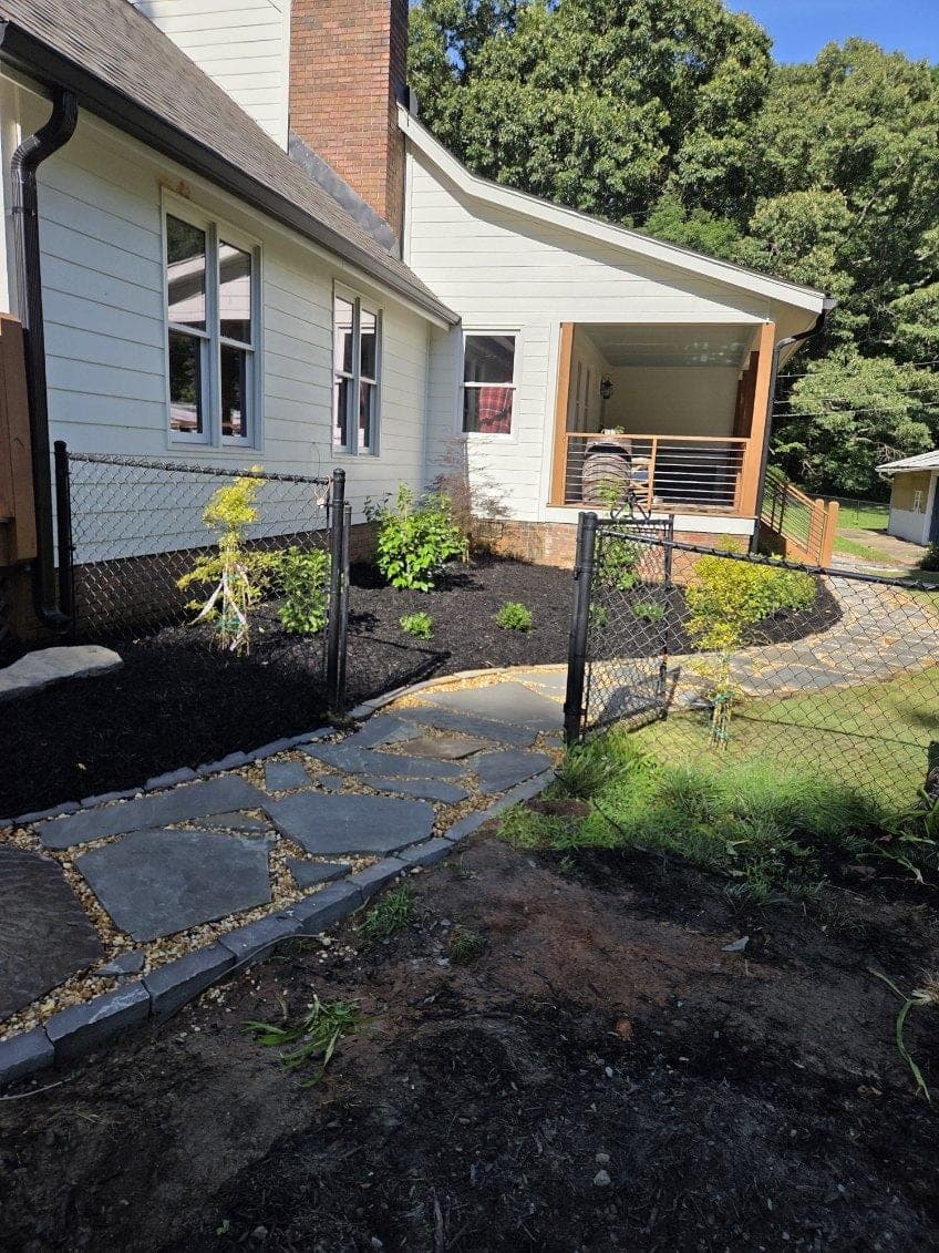 Stepping-stone walkway beside a home with fresh mulch